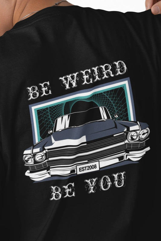 Close-up of classic Cadillac artwork with “Be Weird. Be You.” lettering on a Weirdo 4 Life T-shirt