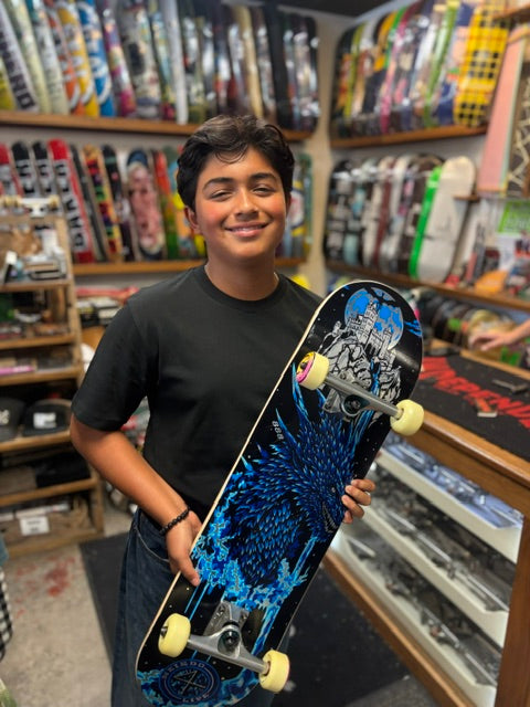 boy holding a skateboard and skateboards in the background 